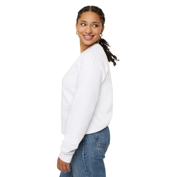 A girl in white sweatshirt and jeans smiling.